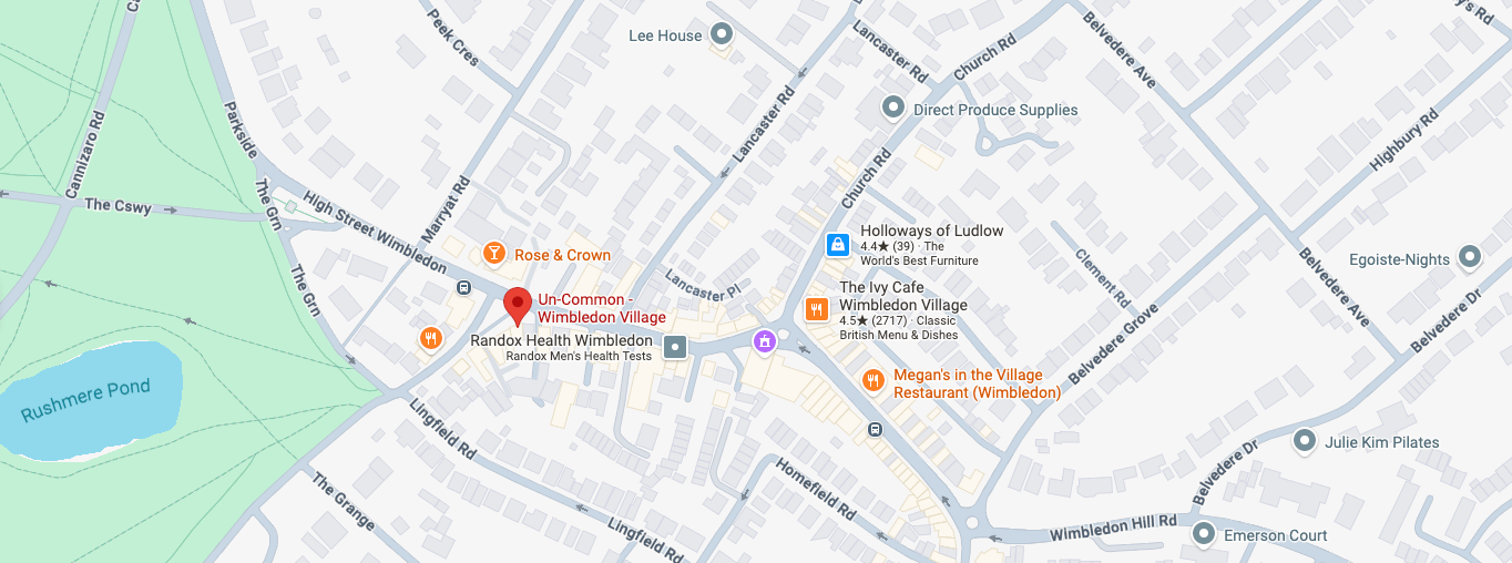 A digital map screenshot showing a street layout with labeled roads, buildings, and several orange location pins around the central area